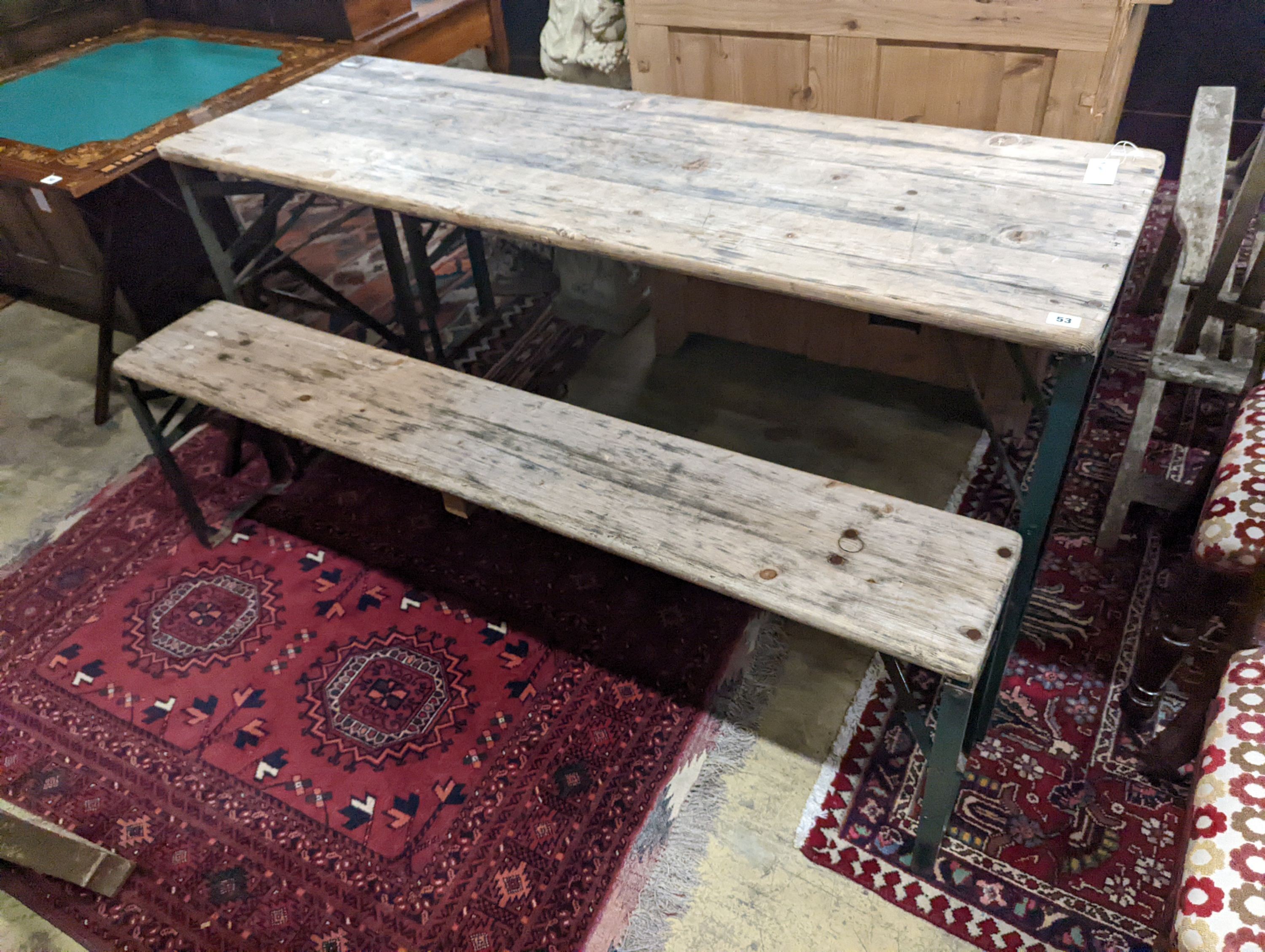 A rectangular pine and painted wrought iron folding garden trestle table, length 150cm, depth 50cm, height 78cm and a pair of matching bench seats